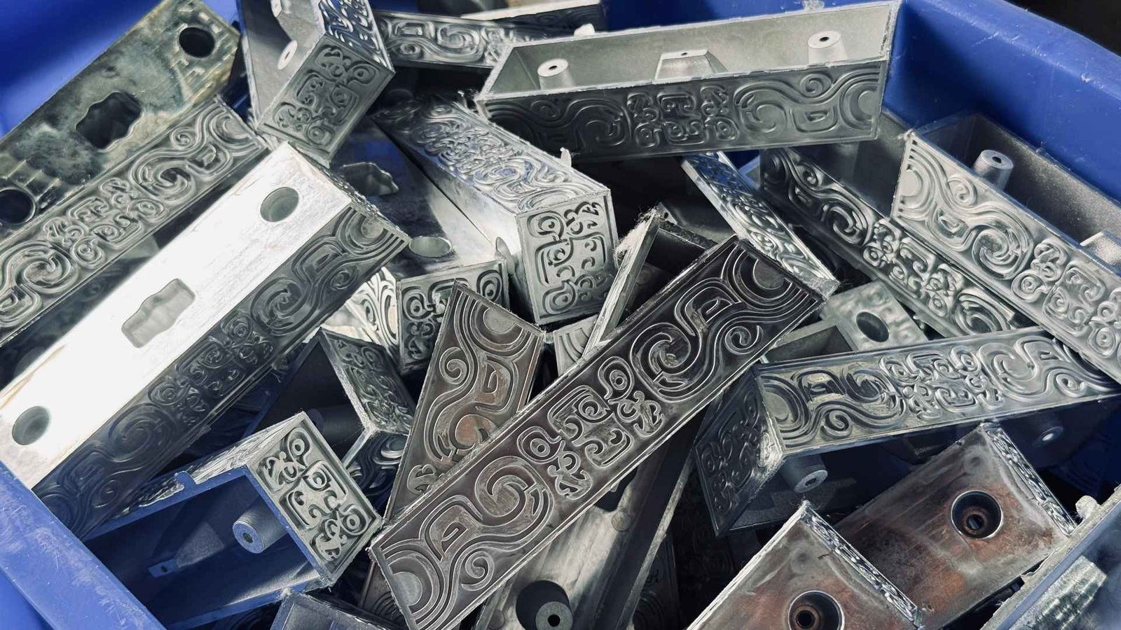 Semi-finished steel window hinge brackets waiting for assembly
