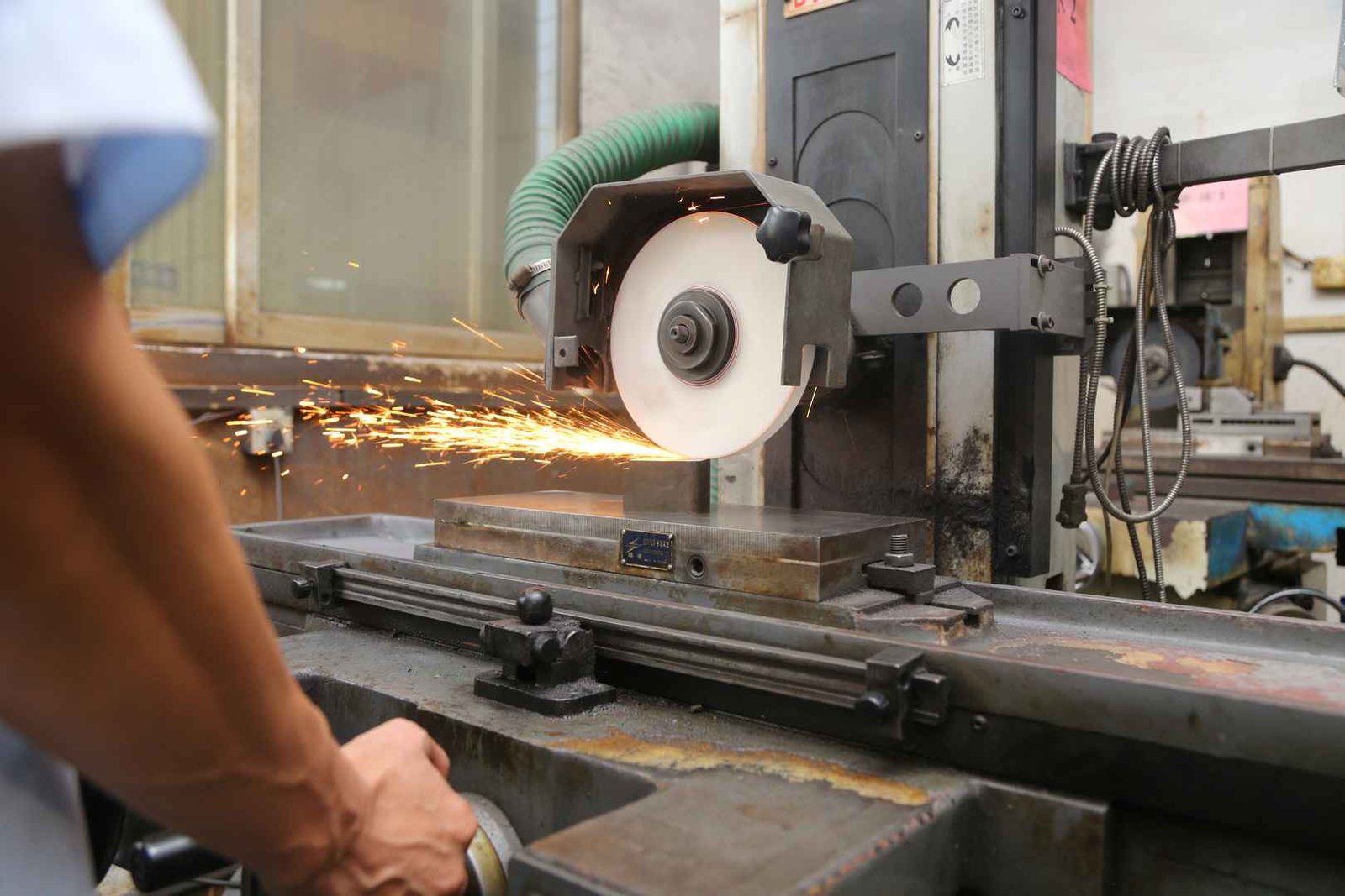 Surface grinding machine processing metal mold with sparks