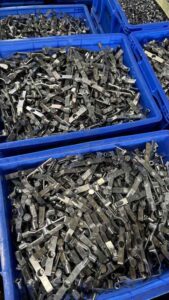 Bulk stamped steel housing brackets for heavy-duty sliding door roller assembly.